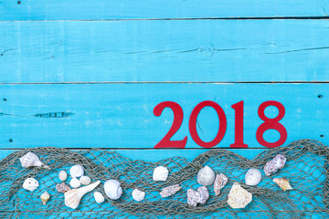 Vacation sign with 2018 in bold red with seashells and netting border; travel message board with copy space