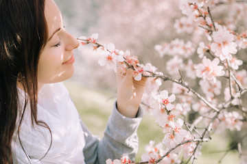 girl smell blooming almonds in the garden