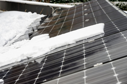 Photovoltaic panels on the roof cover with snow, in the winter