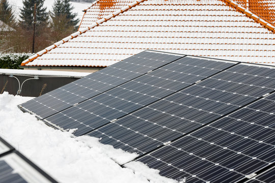Photovoltaic panels on the roof cover with snow, in the winter