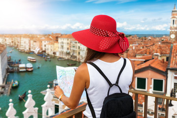 Elegante Touristin genießt den Blick über Venedig mit einem Reiseführer in der Hand
