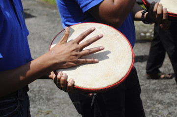Boy plays Kompang during Malay wedding ceremony. Kompang is a Malay traditional drums that usually...