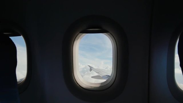 Looking out the window of an airplane as clouds pass by.