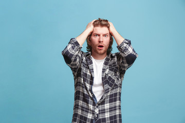 Beautiful man looking suprised and bewildered isolated on blue