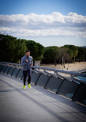 Young athletic man is running in a city park.