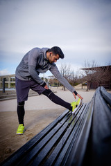 Young athlete man stretching after running in a park