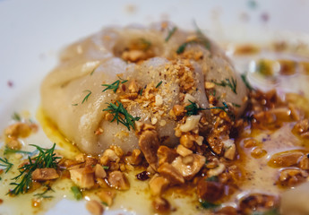Close up on vegetarian variety of manti dumplings with crushed walnuts