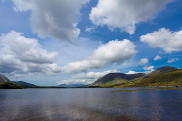 Mountain lake with the clouds on the blue sky in Ireland
