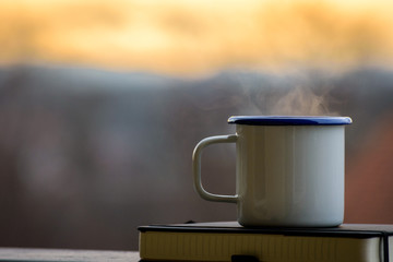 Cup of tea and notebook in warm light.