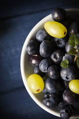 Blueberries and grapes on white bowl