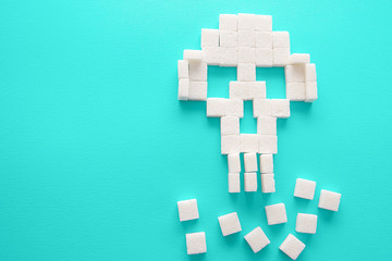 Fototapeta premium The skull made of sugar cubes. Sugar kills. Green background.