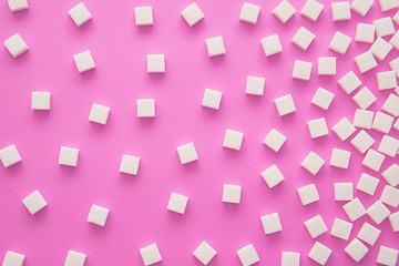Cubes of sugar on pink background