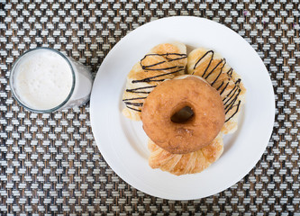 breakfast, donut and croissant on white plate