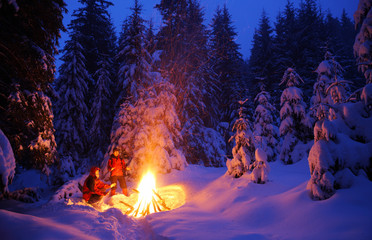 Two tourists are warming up at the fire