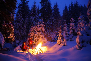 Two tourists are warming up at the fire