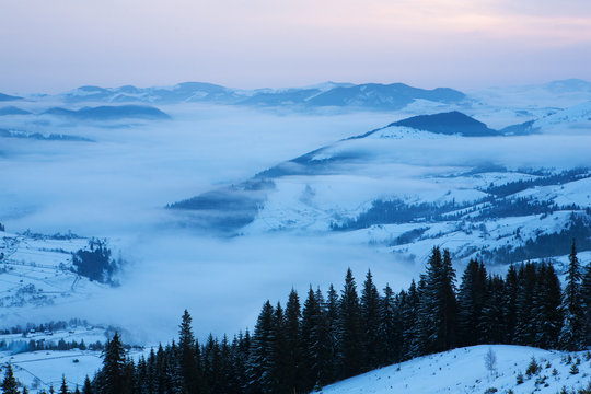 The fog covers the valley at dawn.