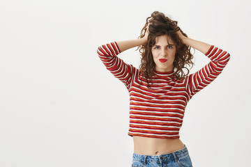 Looking sassy today. Portrait of confident sexy woman touching hair and messing it, grimacing while...