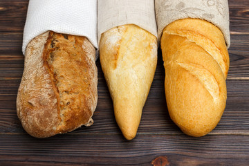 Homemade baguettes on wooden table. close up