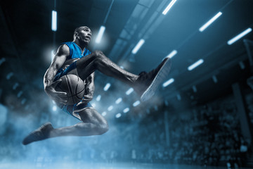 Basketball player on big professional arena during the game. Basketball player making slam dunk. - obrazy, fototapety, plakaty