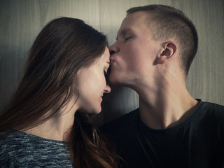 The young man gently and gently kisses the girl. Emotional portrait