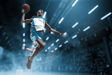 Fototapeta na wymiar Basketball player on big professional arena during the game. Basketball player making slam dunk.