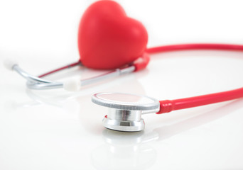 Stethoscope and red heart on white background