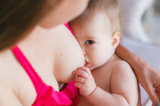 Mother breast feeding her little baby. Close-up shot, focus on face