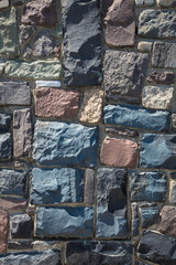 Modern stone wall background texture. Wall from a natural cobblestone stone, vertical background for design.