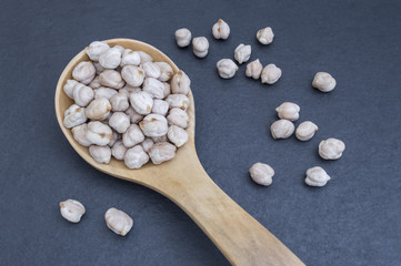spoon full of chickpeas on black background
