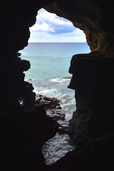 View of the Atlantic ocean through a large hole inside the caves of Hercules, Morocco