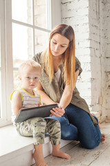 Home learning and education concept. Mom and child using digital tablet