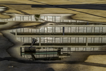 Building reflection in a puddle, after rain. Puddle with reflection of a modern building facade in Budapest, Hungary.