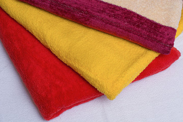 Colorful folded towels stack closeup picture.