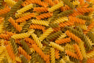 Italian fusilli pasta salad with pesto genovese, colorful tomatoes and basil leaves on dark wooden...