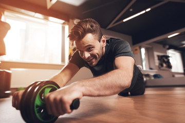 A man in the gym. He leads a healthy lifestyle. Man is engaged on the simulator in the support lying down.