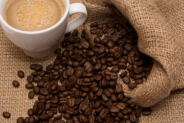 A cup of latte coffee and coffee beans.
