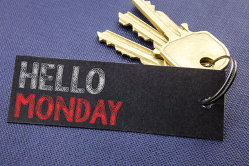 Handwritten text showing Hello Monday. Business concept writing for Day Week Start Written on note paper attached to the key, black background with space close up