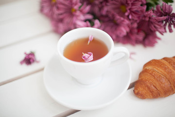 Female hands holding cups of coffee on rustic wooden background