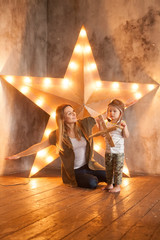 Young Mother and her Child Boy Having Fun with Wooden Plane Toy on Studio Background