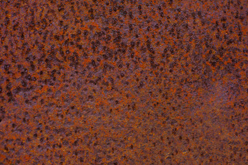 Rusty yellow-red textured metal surface. The texture of the metal sheet is prone to oxidation and corrosion. Grunge background