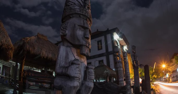 Balanese Statue of a man timelapse zooming in at night in front of street