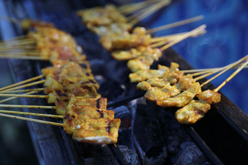 Roasting satays on coal grill , Asian food