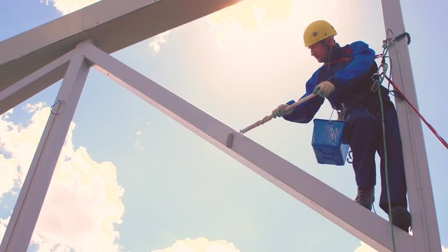 An industrial climber suspended on insurance.
