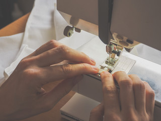 Sewing process close-up on the sewing machine. The presser foot and needle of the sewing machine...