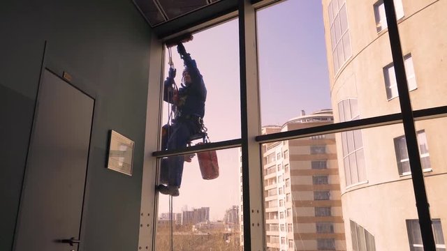 Windows washing skyscraper mountain climber