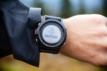 Hiker on mountain trail checking compass