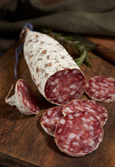 Salami slices on the wooden table. Spicy and tasty.