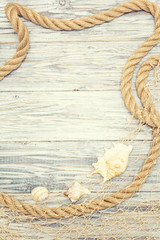 Seashell and rope on a light wooden background