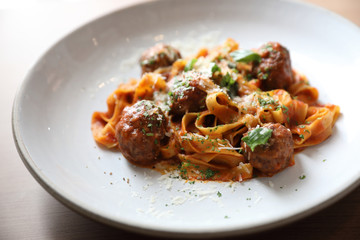 Spaghetti pasta with beef meatballs and tomato sauce on wood background . italian food