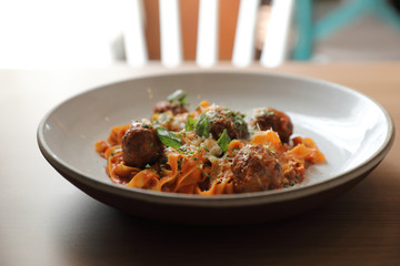 Spaghetti pasta with beef meatballs and tomato sauce on wood background . italian food